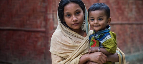 A young Rohingya girl holds her brother outside a youth club in Cox's Bazar, Bangladesh, in this file picture. — Courtesy photo