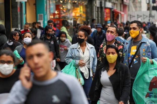 Brazilians take precautionary measures by wearing masks as they go about their business.