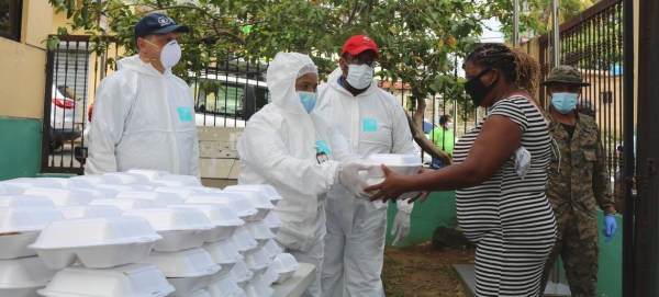 A woman in the Dominican Republic receives food from a community kitchen set up to help fight hunger triggered by the COVID-19 pandemic. — Courtesy photo