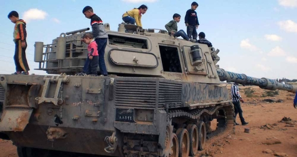 File photo shows children playing on an abandoned tank in Libya. — courtesy UNMAS/Maximilian Dyck
