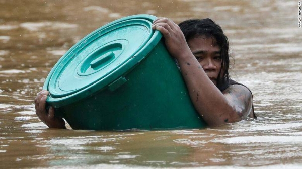 A Marikina resident clings to a plastic container as floodwaters hit the area. — Courtesy photo
