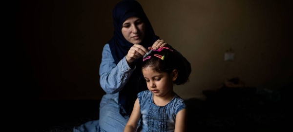 Thirty-two-year-old Syrian refugee Wafaa pins her three-year-old daughter Yasmine's hair at their home in Barja, Lebanon. They are awaiting resettlement to Norway. — Courtesy photo
