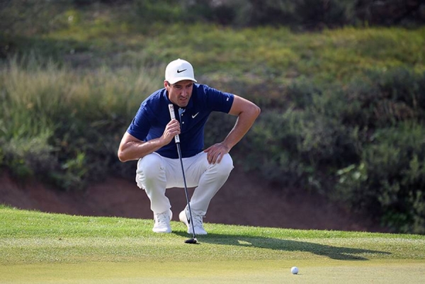 Andy Sullivan of England interacts with his caddie Thomas Riley  on the 18th hole during Day Three of the Golf in Dubai Championship at Jumeirah Golf Estates on Friday in Dubai, United Arab Emirates. (Photo by Andrew Redington/Getty Images)