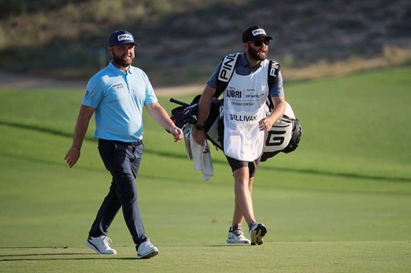 Andy Sullivan of England interacts with his caddie Thomas Riley  on the 18th hole during Day Three of the Golf in Dubai Championship at Jumeirah Golf Estates on Friday in Dubai, United Arab Emirates. (Photo by Andrew Redington/Getty Images)