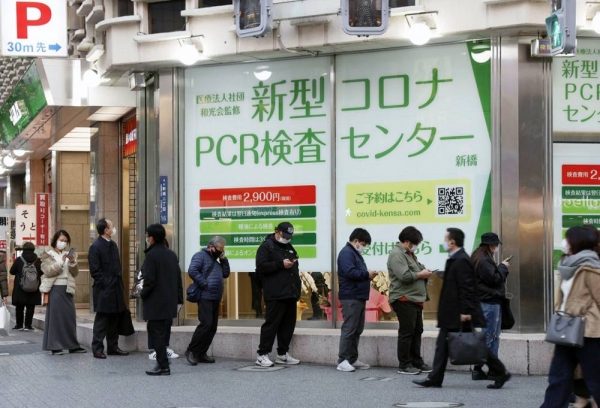 People line up as a PCR test center opens on Friday, in front of JR Shimbashi Station in Tokyo. — courtesy Kyodo