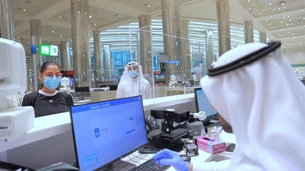 An immigration official checks the documents of a passenger at Dubai International Airport in this file picture. — Courtesy WAM