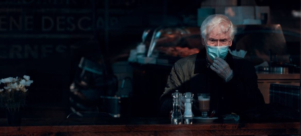 A man wears a face mask and gloves while sitting in a cafe in Glasgow, Scotland, in this file picture. — Courtesy photo