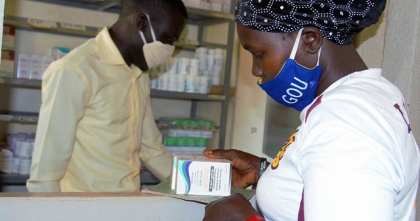 A woman living with HIV receives her medication at a health center in Uganda during the COVID-19 pandemic. — courtesy UNICEF/Francis Emorut