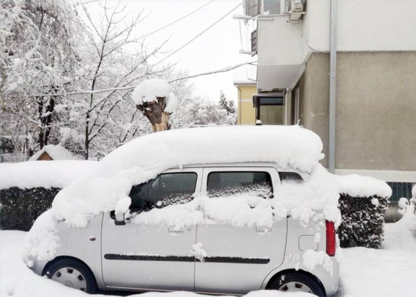 A car is covered in snow in Belgrade. Days of heavy rain and snow across the Balkans left homes and fields flooded Monday, disrupted traffic on highways and at ports and caused power outages.