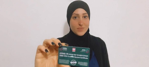 An Arab-Israeli woman shows her COVID-19 card which shows she has been vaccinated against the virus. — Courtesy photo