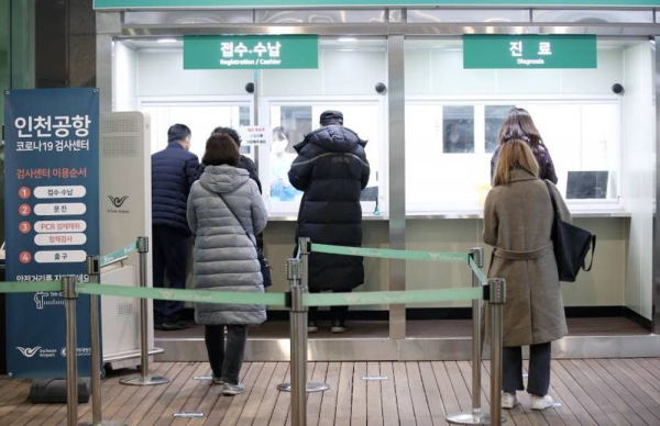 In this file photo, people apply for COVID-19 tests at a testing station set up for departing passengers at the second terminal of Incheon International Airport, west of Seoul, on Jan. 8, 2021. — courtesy Yonhap