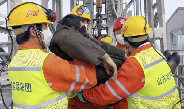 In this photo released by Xinhua News Agency, rescuers carry a miner who was trapped in a gold mine in Qixia City in east China's Shandong Province, Sunday.
