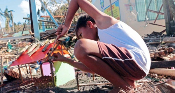 
A boy makes a small house using plastic and debris. His home was completely swept away when Typhoon Goni hit the Philippines in November 2020.
— courtesy UNICEF/Nino Luces