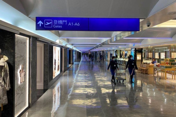 Staff wearing masks to prevent the spread of the coronavirus walk past shops at Taipei’s Taoyuan International Airport.  File courtesy photo