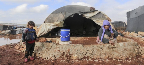 A woman tries to rescue her belongings after floods inundated her camp in northwest Syria. — Courtesy photo