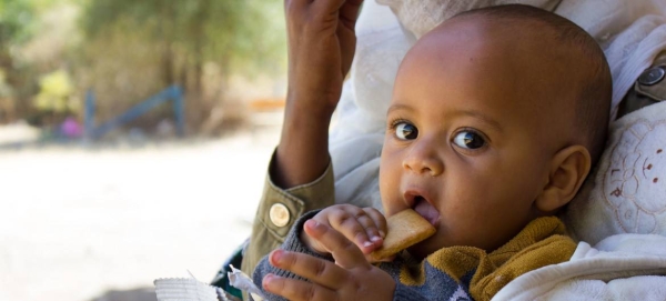 A seven-month-old baby displaced with his mother due to conflict in Tigray eats a high energy biscuit to boost his nutrition levels. — Courtesy photo