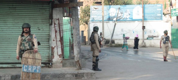 Women walking past Indian security forces in Srinagar, summer capital of the Indian state of Jammu and Kashmir. File courtesy photo
