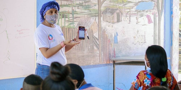 A teacher explains how to use the application that will allow students to access educational material. — courtesy El Origen Foundation