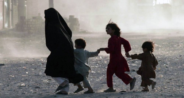 File photo shows a family running across a dusty street in Herat, Afghanistan.— courtesy UNAMA/Fraidoon Poya