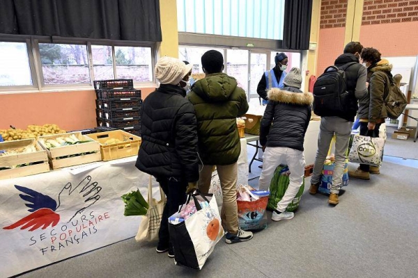 Students queue to receive a food aid package during a distribution by French charity 'Secours Populaire' in Strasbourg, eastern France, in this file courtesy photo.