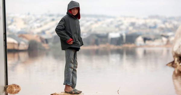 

A child is surrounded by floodwater in Kafr Losin Camp in northwestern Syrian. — courtesy UNICEF/Khaled Akacha