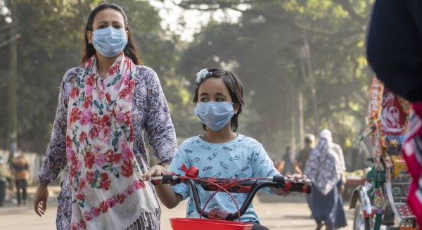 A young girl, accompanied by her mother — both wearing masks — at a park in Dhaka, Bangladesh, in this file courtesy photo.
