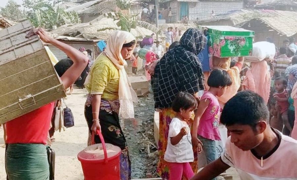 IOM personnel at Kutupalong refugee camp in Bangladesh. In the background are the tens of thousands of refugees displaced after the fire. — courtesy IOM Photo