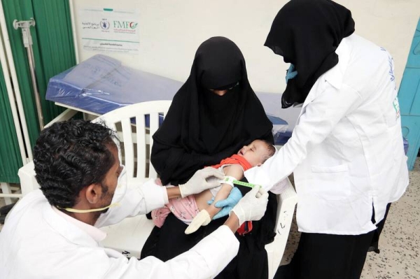 Amwaj Mohammed and her child, Saleh Ibrahim, 10 months old, suffering from malnutrition, while they were going to the medical center to examine by the health counselor at the health center in Al-Dhale city, Yemen. The health workers — Dhuriyat Ali and and Radfan Ali — take the measurement of Saleh, 10 months old, who suffers from malnutrition. — courtesy WFP/Saleh Bin Haiyan