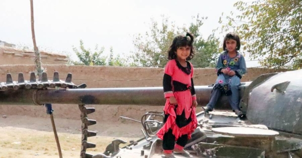 Children in Kandahar play on a destroyed tank, a relic of a past war with the then Soviet Union. — courtesy UNAMA Photo/Mujeeb Rahman Hotaki