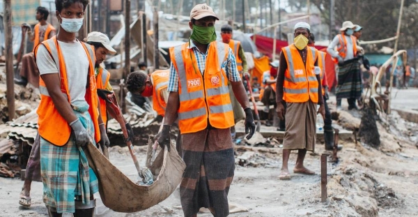 Rohingya volunteers clear debris to reconstruct shelters after the devastating fire at the Kutupalong refugee camp, in Cox’s Bazar, Bangladesh. — courtesy WFP/Mehedi Rahman