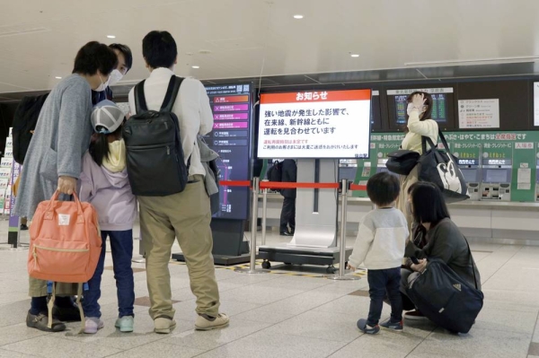 People wait outside the ticket gates of JR Sendai Station after an earthquake shook the area, halting bullet train lines. — courtesy Kyodo