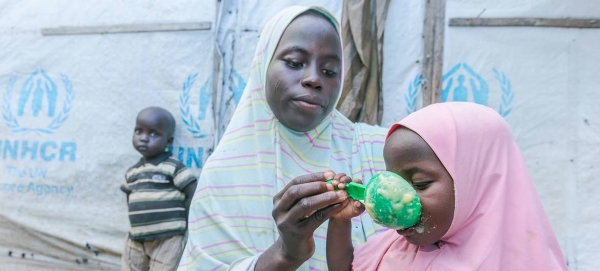 A mother prepares food for her children with cereal she received from a World Food Programme (WFP) distribution site in Maiduguri, Nigeria. — Courtesy photo
