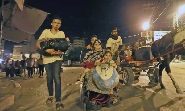 Palestinians in Gaza seen fleeing their homes Thursday night to take refuge in UNRWA schools. — courtesy Twitter