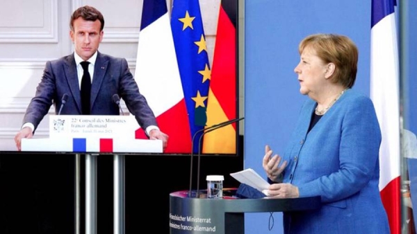 A videograb of German Chancellor Angela Merkel speaking with French President Emmanuel Macron looking on from TV during the   Franco-German Council of Ministers meet discussing Danish intelligence services helped Washington to spy on European politicians.