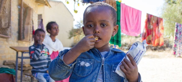 A three-year-old girl in western Tigray eats a high-energy biscuit to boost her nutrition levels. — Courtesy file photo
