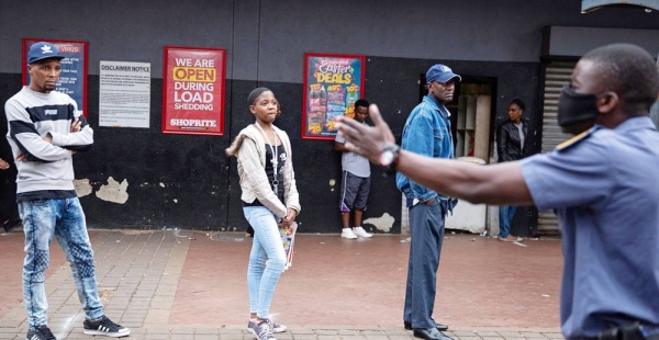 

Police order shoppers queuing up outside a shop to maintain a safe distance from each other in Hillbrow, Johannesburg, South Africa, 30 March 2020. — courtesy IMF Photo/James Oatway