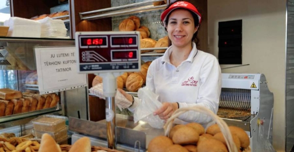 A shop worker sells bread in a bakery in Tirana, Albania — courtesy ILO Photo/Marcel Crozet