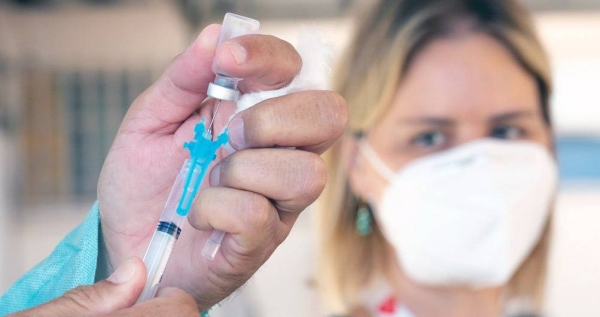 A health care worker prepares to administer a COVID-19 vaccine in Brazil. — courtesy PAHO/Karina Zambrana