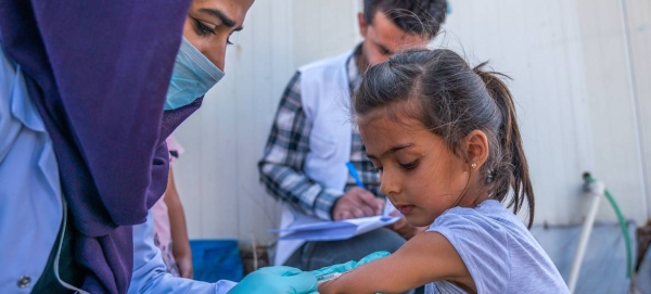 A young girl receives a vaccination against polio and measles in Iraq after fleeing conflict in northeastern Syria. — Courtesy file photo

