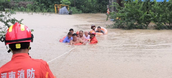 Rescuers pull villagers from flood waters in Xingyang city in China's Henan Province. — Courtesy photos
