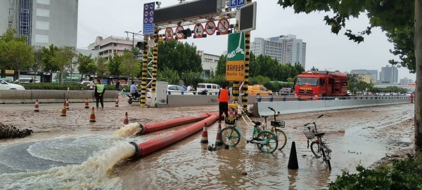 Rescuers pull villagers from flood waters in Xingyang city in China's Henan Province. — Courtesy photos
