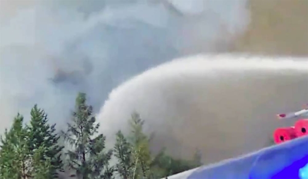 Volunteers and firefighters battle to control the wildfire in the clearing of a Siberian forest.