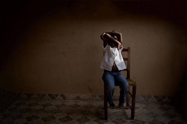 An eight-year-old girl hides her face at a UNICEF-supported center in Haiti that provides temporary care and support for trafficked children while authorities search for their parents in this courtesy file photo.