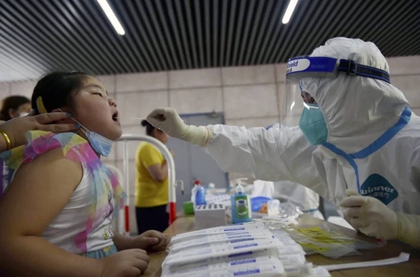 A nurse takes a throat swab in a new round of coronavirus testing in Nanjing, China. — courtesy Chinatopix