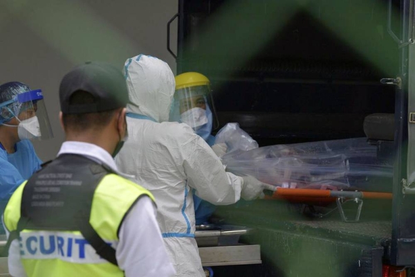 A medical staff load an unidentified body of the person who was killed by a gunman at a military base in Kuching, Sarawak, Malaysia, Friday. — courtesy photo