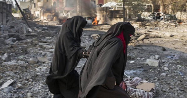 Civilians pass a burning automobile following a suicide car bombing.in Mosul, Iraq. — courtesy UNHCR/Ivor Prickett