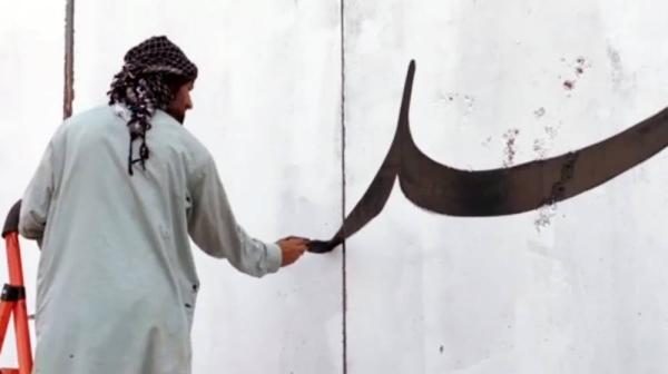 A videograb shows that the Taliban have started to work to change the face of Afghanistan with fighters whitewashing murals.