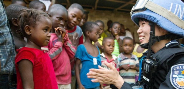 A Chinese police officer deployed to the UN Mission in Liberia (UNMIL), talks to a young girl whilst on patrol (file photo). — courtesy UN Photo/Albert González Farran