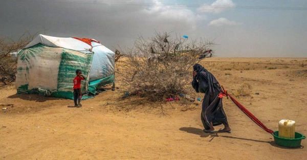 An elderly woman drags water back to her tent in a displacement camp in Abs, near the Saudi border in northern Yemen. — courtesy UNOCHA/Giles Clarke