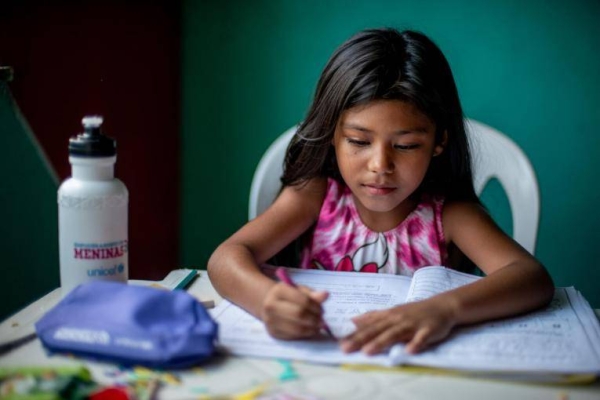 Ágata Melo, 8, does school activities at her home in Vigia, in the northern Brazilian state of Pará, in the Amazon region.